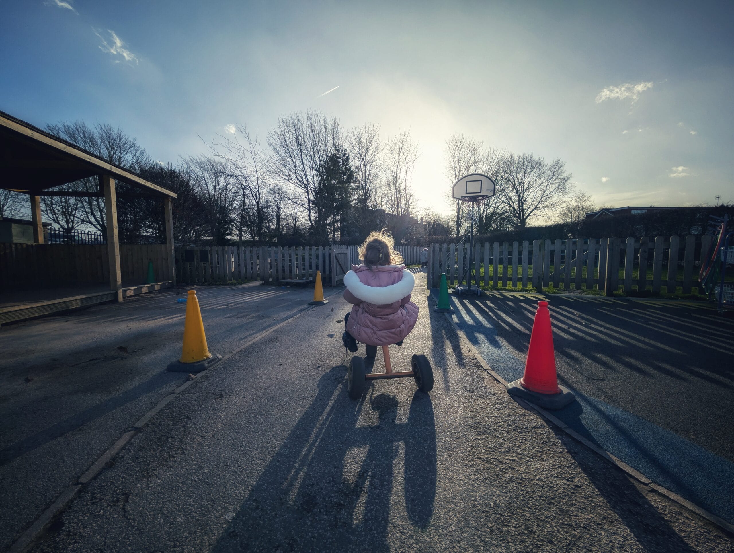 Nursery Girl riding a tricycle in playground